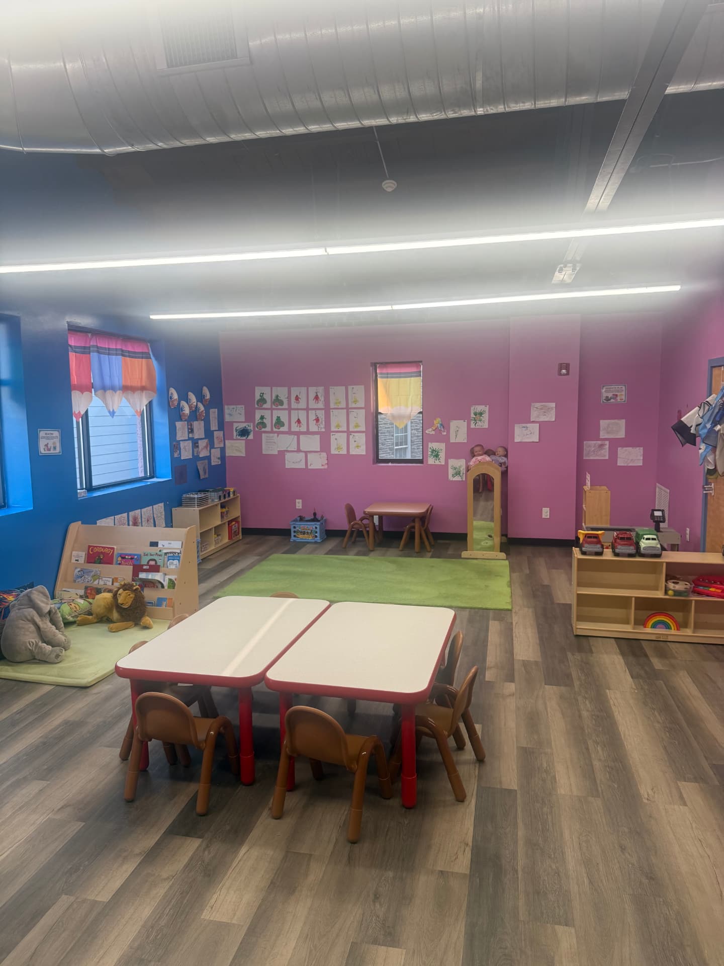 Bright toddler classroom with reading nook and artwork